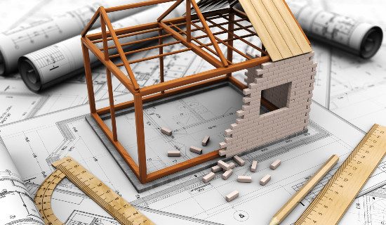 Maquette de maison en construction sur des plans